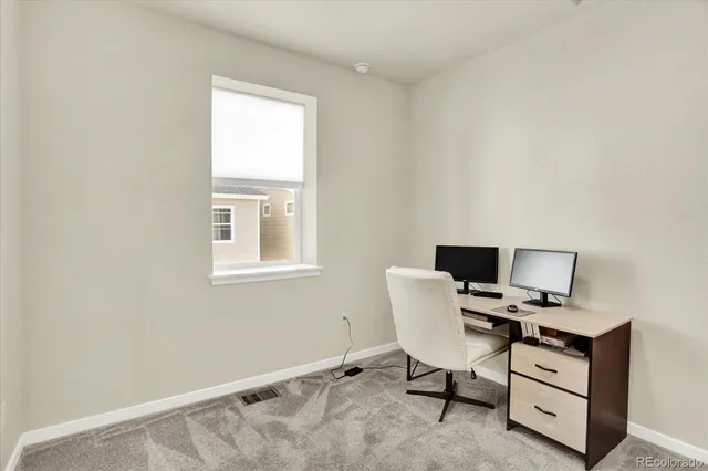 a view of a workspace with furniture and a window