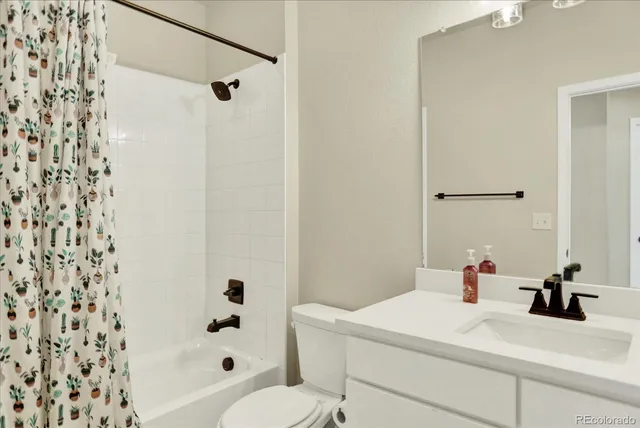a bathroom with a sink a toilet and shower curtain