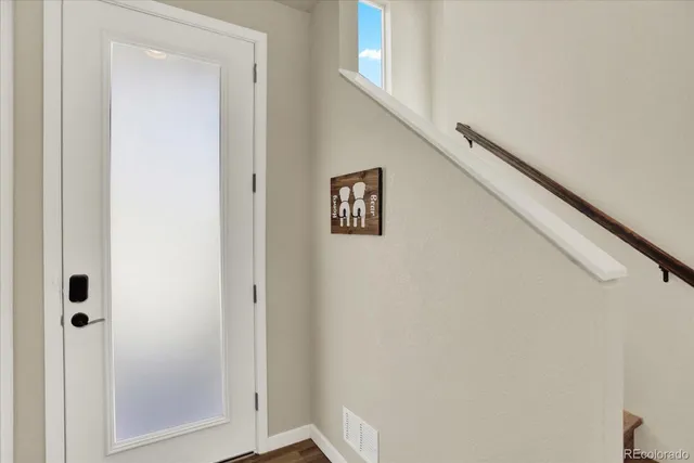 a view of a hallway with wooden floor and entryway