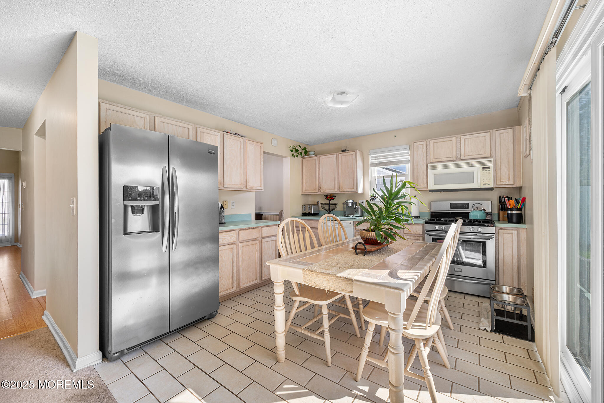 33 Bryce Canyon Road Howell, NJ 07731 - Photo 13 of 44 a kitchen with stainless steel appliances granite countertop a refrigerator a stove a microwave oven a sink with island and chairs