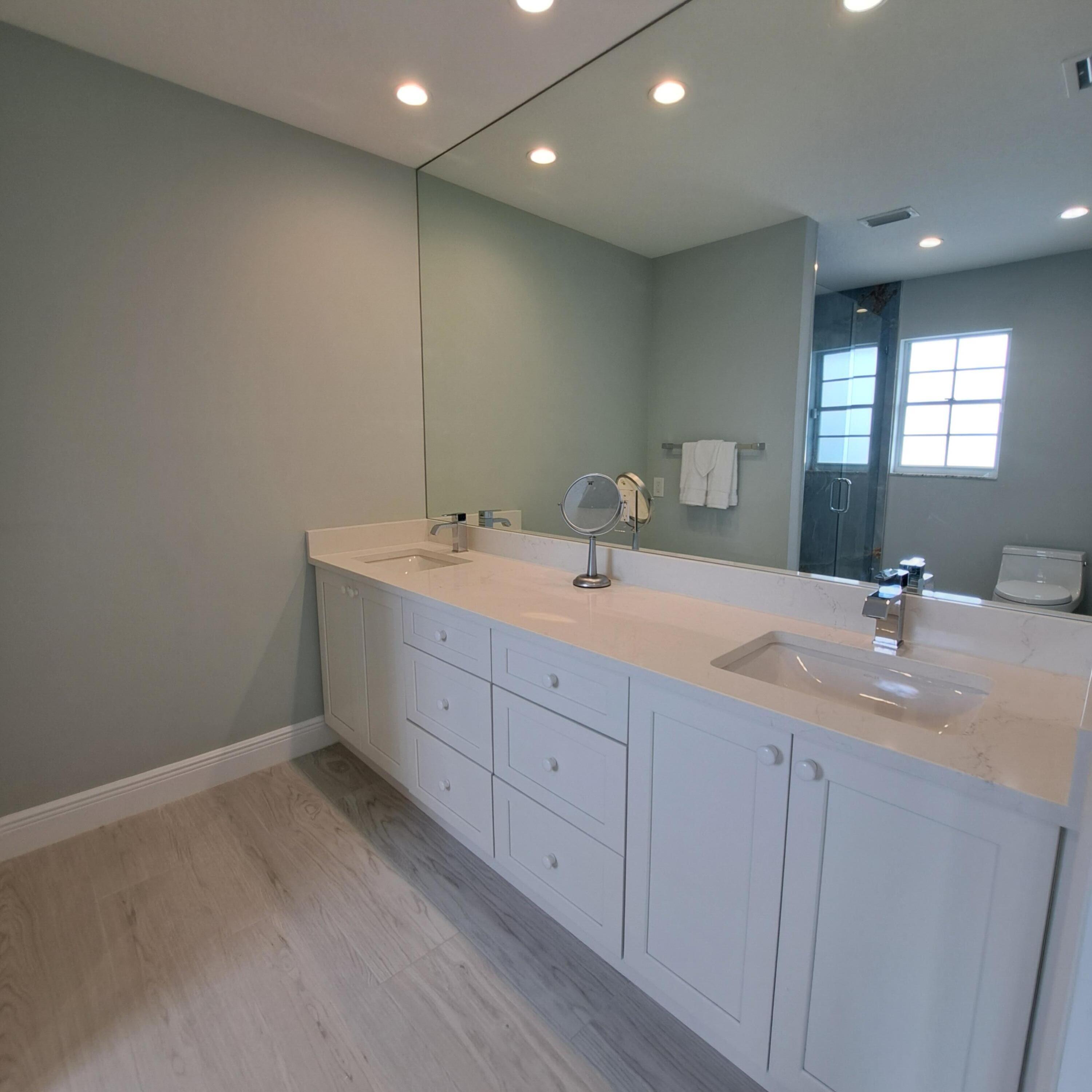 904 Ocean Dunes Circle Jupiter, FL 33477 - Photo 19 of 49 a bathroom with a double vanity sink and a mirror