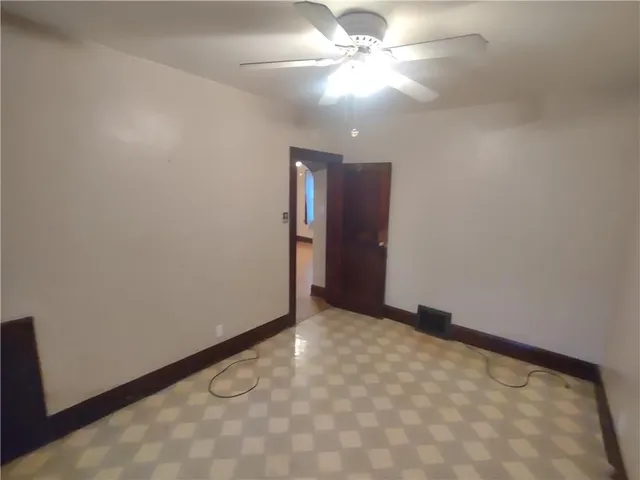 an empty room with closet and a chandelier fan