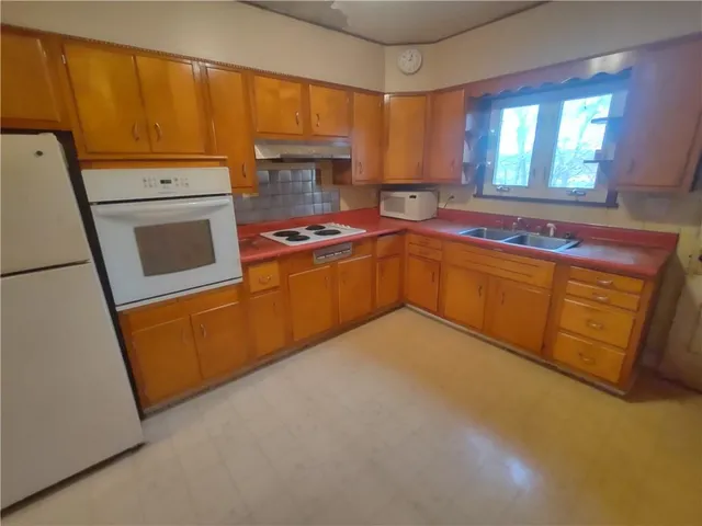a kitchen with stainless steel appliances a stove a sink and a refrigerator