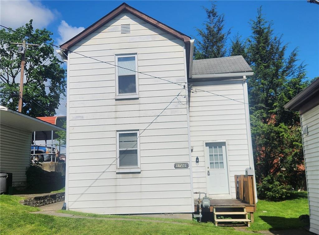1726 Ridge Avenue Coraopolis, PA 15108 - Photo 1 of 41 a view of a white house with a yard and a table and chair under an umbrella