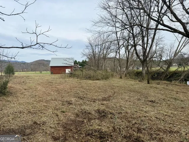 a view of a yard with wooden fence