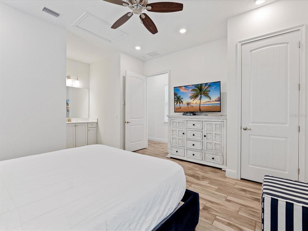 8092 Knee Deep Road Kissimmee, FL 34747 - Photo 17 of 26 a spacious bedroom with a bed and a flat screen tv
