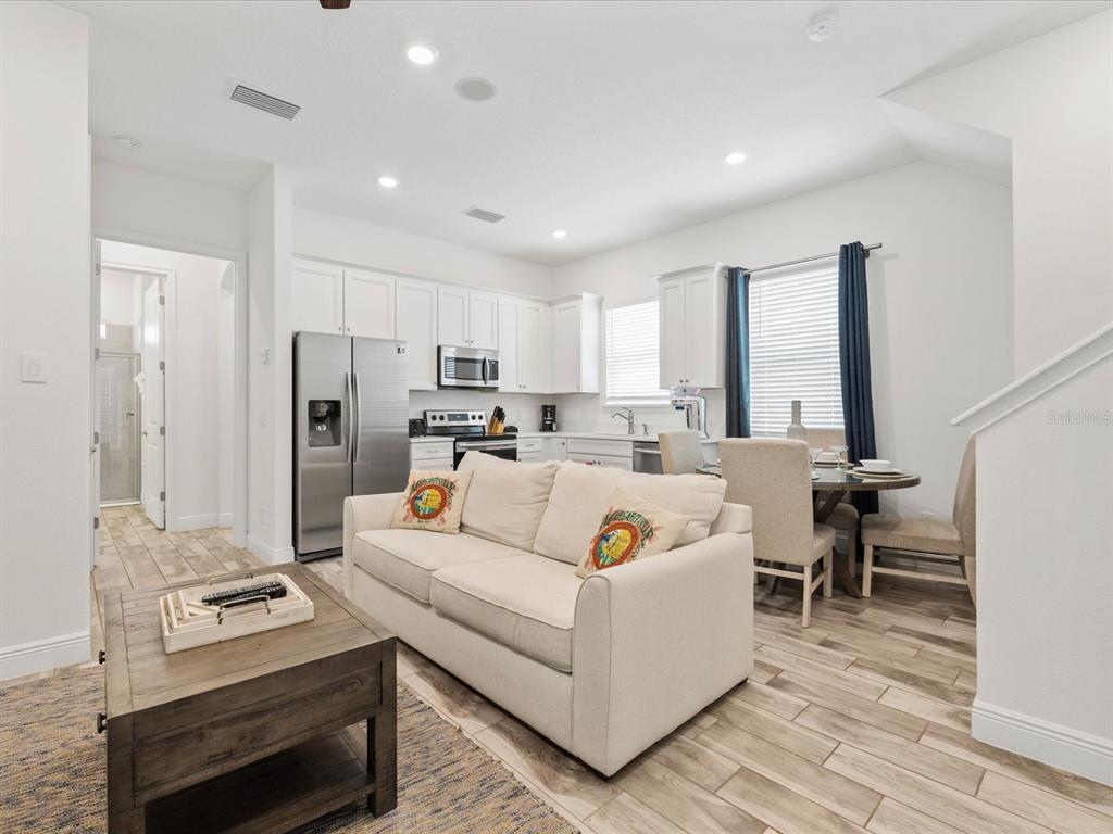8092 Knee Deep Road Kissimmee, FL 34747 - Photo 4 of 26 a living room with furniture and a refrigerator