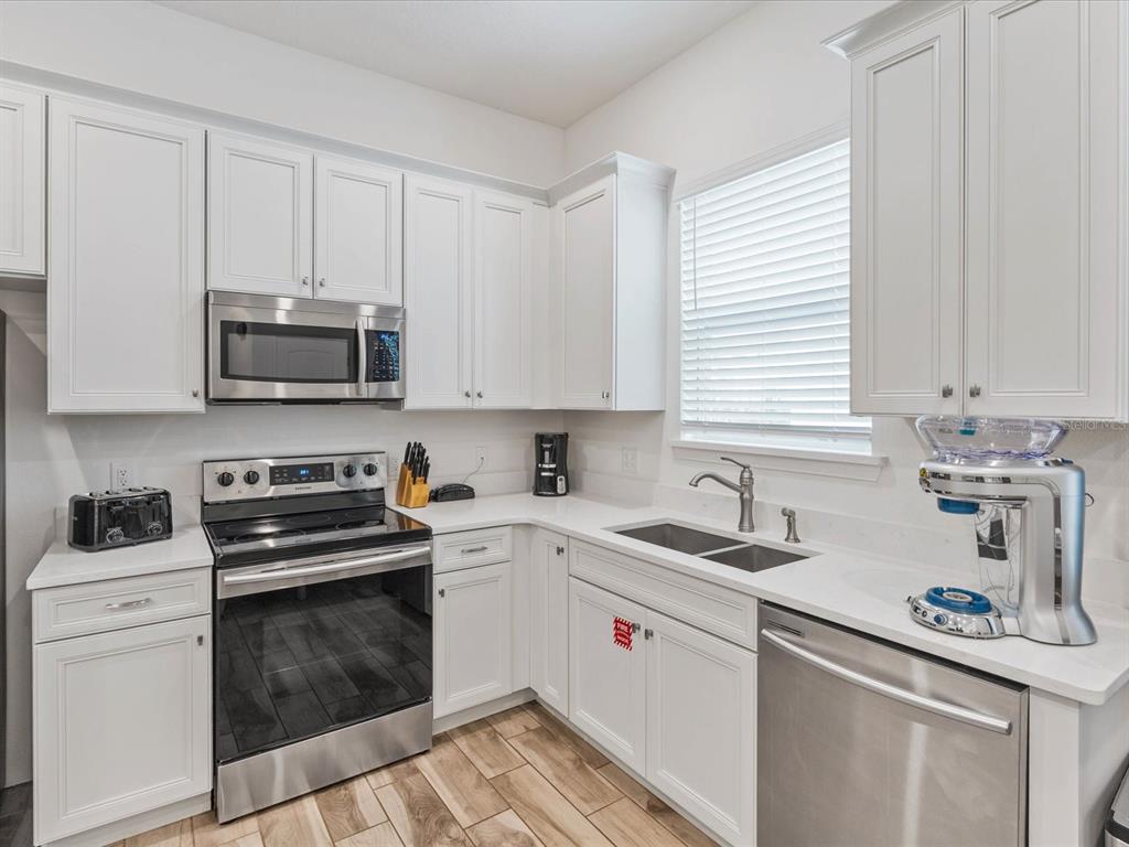 8092 Knee Deep Road Kissimmee, FL 34747 - Photo 7 of 26 a kitchen with stainless steel appliances granite countertop a sink a stove and cabinets