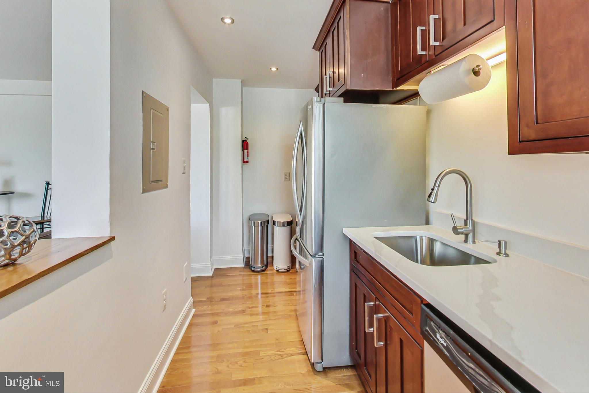 1451 Park Road Northwest, Unit 303 Washington, DC 20010 - Photo 12 of 27 a kitchen with stainless steel appliances a sink and a refrigerator