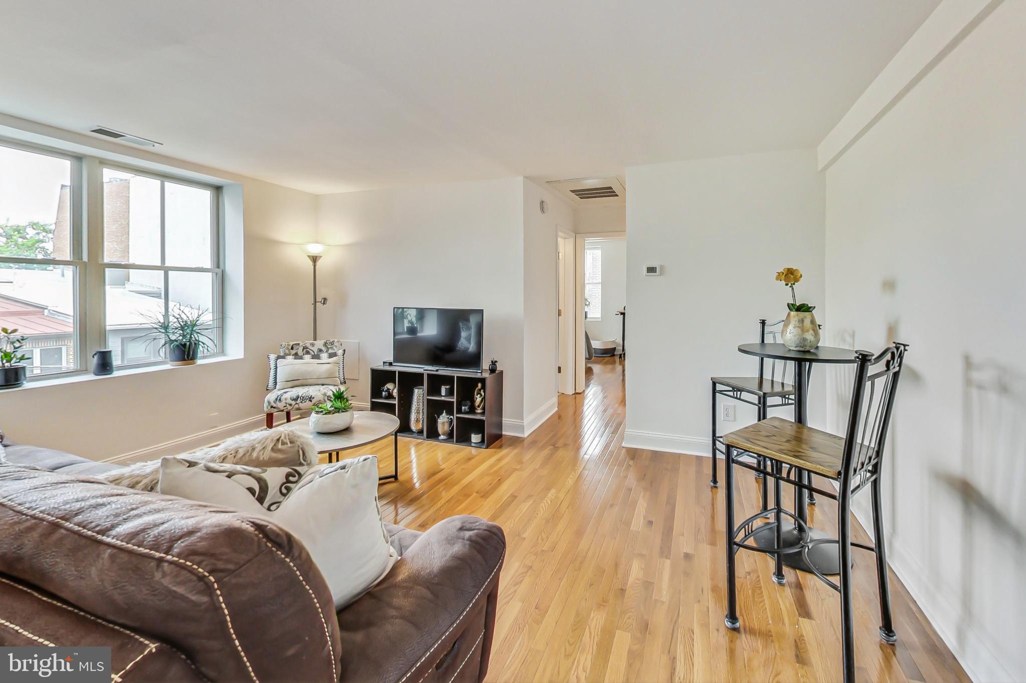 1451 Park Road Northwest, Unit 303 Washington, DC 20010 - Photo 6 of 27 a living room with furniture a flat screen tv and a large window
