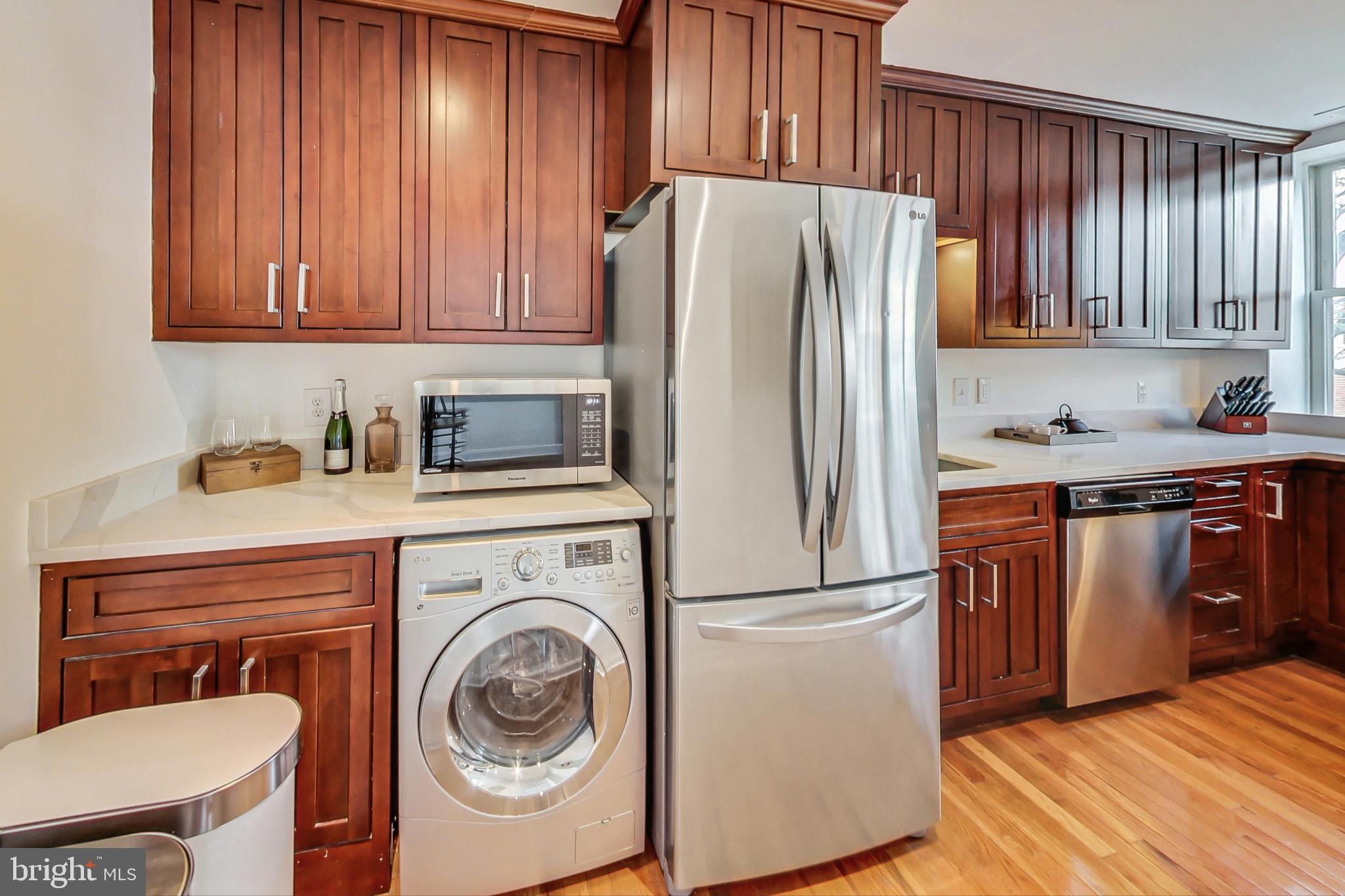 1451 Park Road Northwest, Unit 303 Washington, DC 20010 - Photo 9 of 27 a kitchen with stainless steel appliances granite countertop a refrigerator sink and cabinets