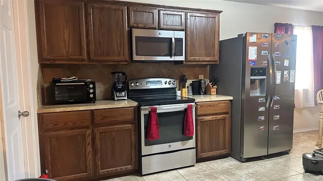 a kitchen with stainless steel appliances granite countertop a refrigerator stove and microwave