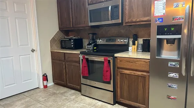 a kitchen with stainless steel appliances granite countertop a stove and a refrigerator