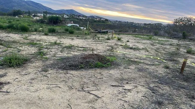 a view of a dry yard with wooden fence
