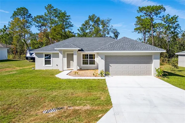 a front view of a house with yard patio and green space