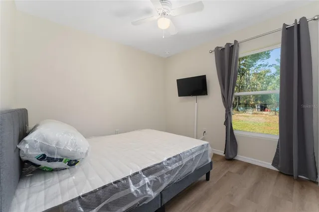 a bedroom with a bed and large window