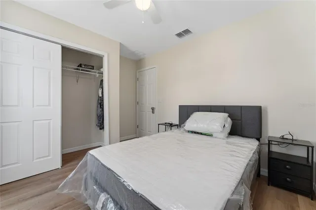 a bedroom with a bed and wooden floor