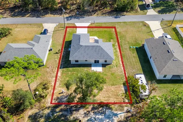 an aerial view of a house with a yard basket ball court and outdoor seating