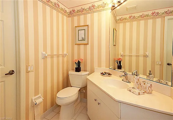 a bathroom with a sink a toilet and a mirror
