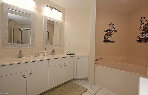 a bathroom with a tub sink and mirror