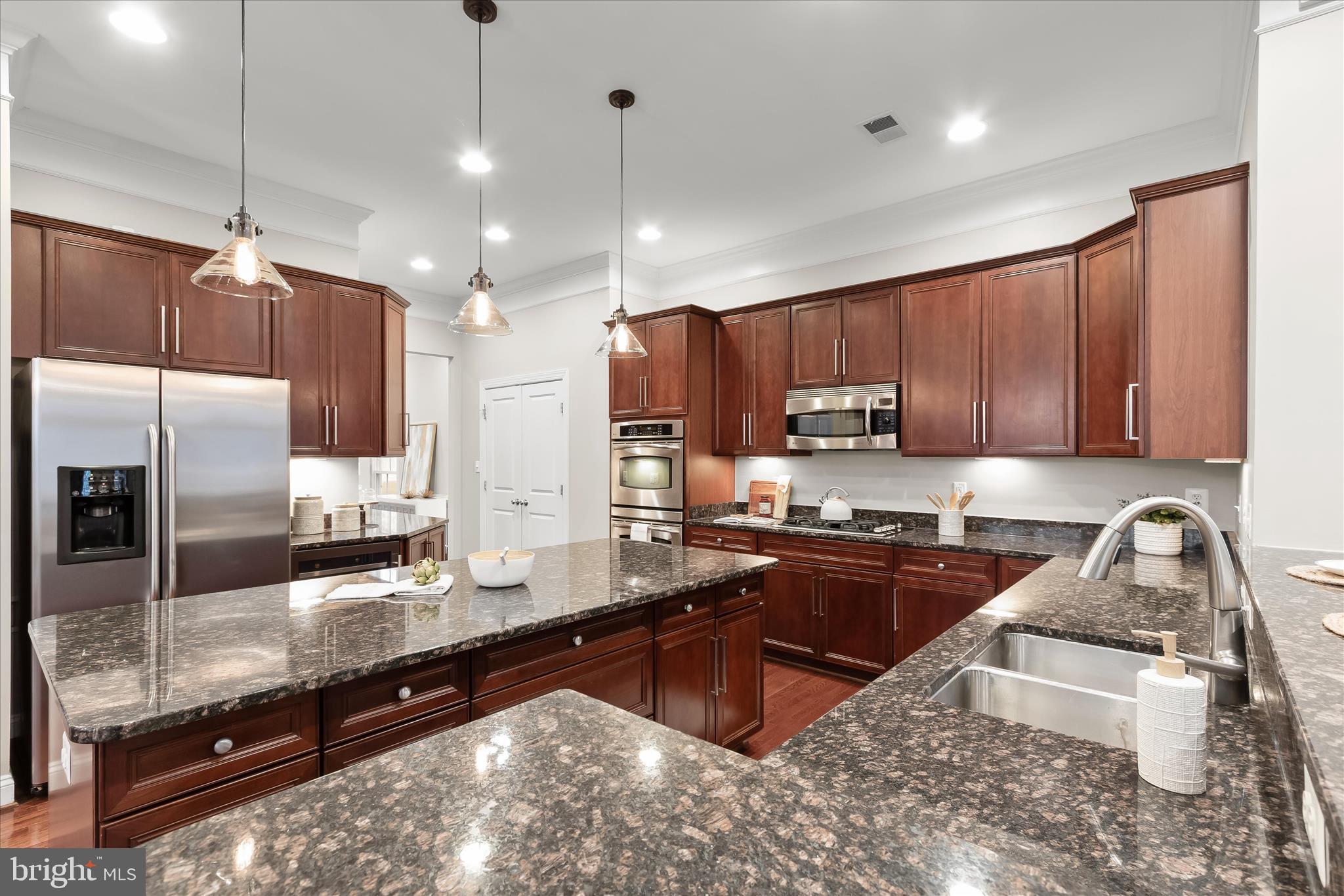 7650 Midtown Road Fulton, MD 20759 - Photo 18 of 76 a kitchen with granite countertop wooden cabinets a stove a oven and a refrigerator