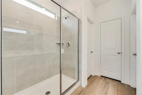 a bathroom with a shower and a glass door