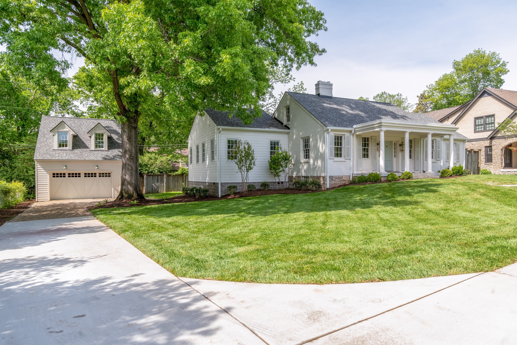 a front view of a house with a garden and trees