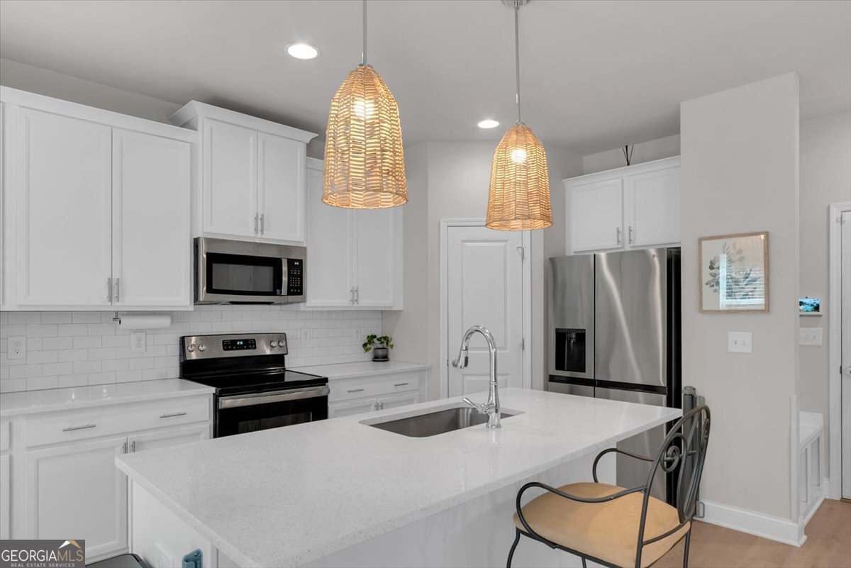 2099 Easterwood Court Decatur, GA 30032 - Photo 12 of 38 a kitchen with stainless steel appliances kitchen island granite countertop a refrigerator a stove a microwave oven a sink with a dining table and chairs