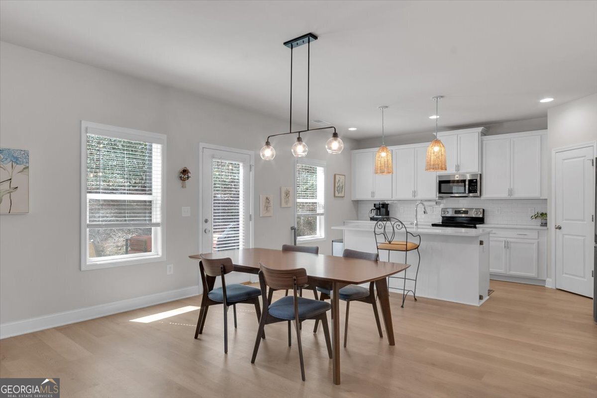 2099 Easterwood Court Decatur, GA 30032 - Photo 10 of 38 a kitchen with stainless steel appliances kitchen island granite countertop a dining table chairs and white cabinets