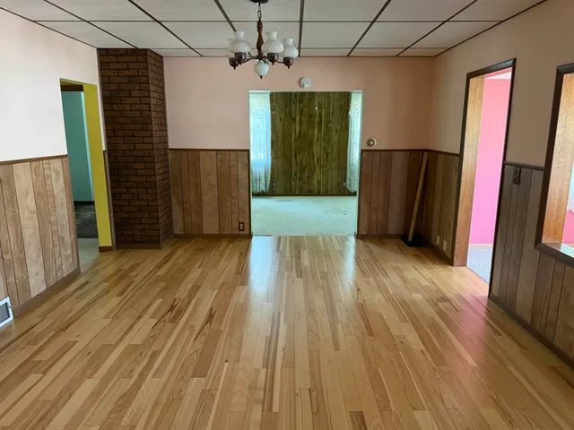 a view of a hallway with wooden floors and stairs