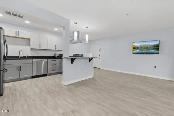 a kitchen with stainless steel appliances granite countertop a sink a stove a refrigerator and cabinets