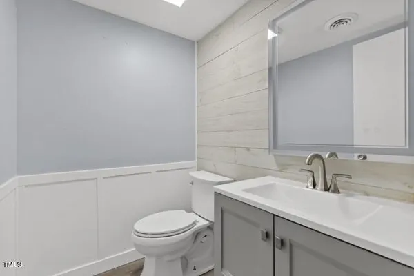 a bathroom with a sink a toilet and a mirror