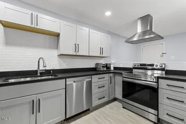 a kitchen with granite countertop white cabinets stainless steel appliances and sink