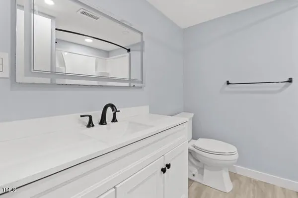 a bathroom with a sink a toilet and a mirror