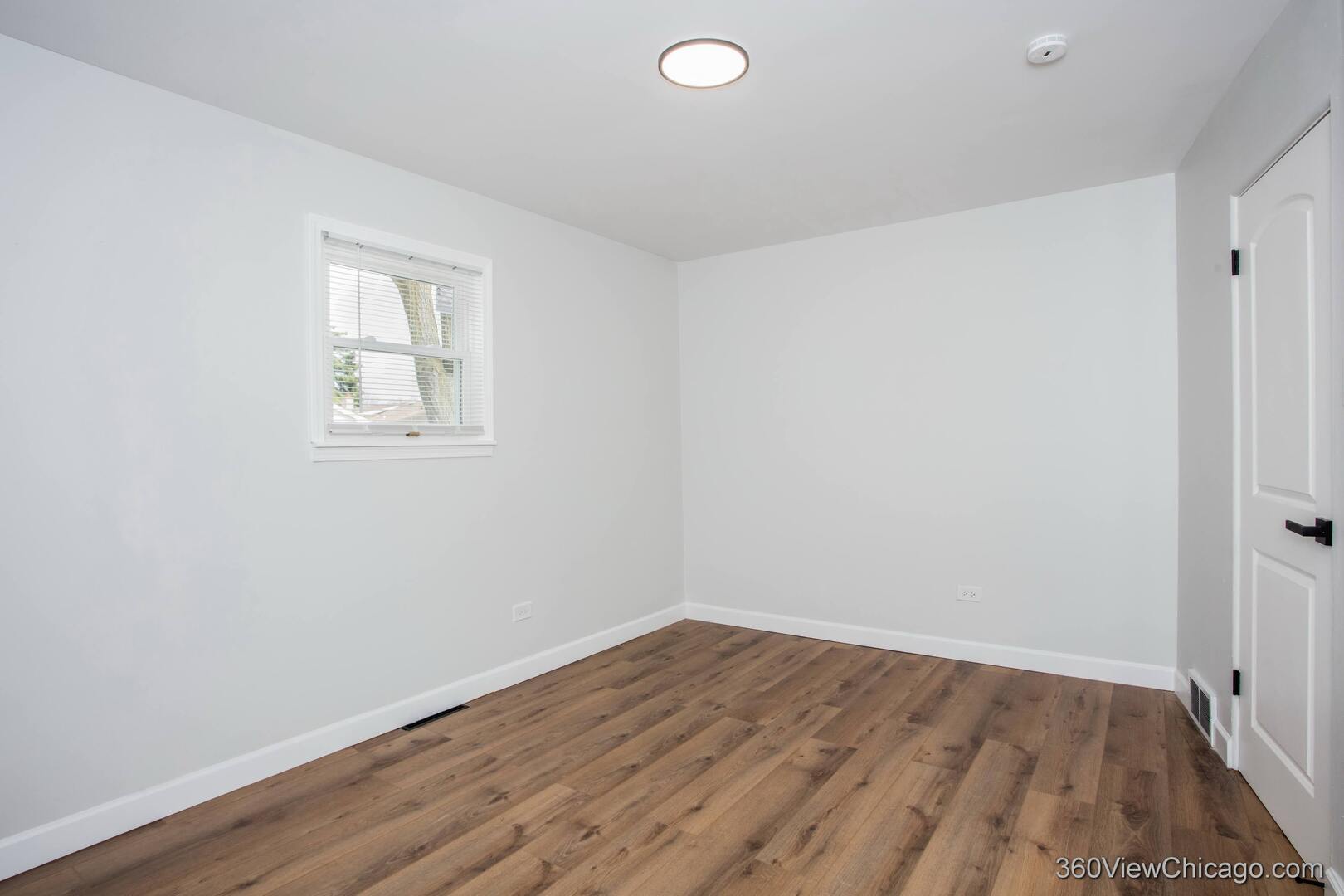 8651 44th Street Lyons, IL 60534 - Photo 12 of 31 an empty room with wooden floor and windows