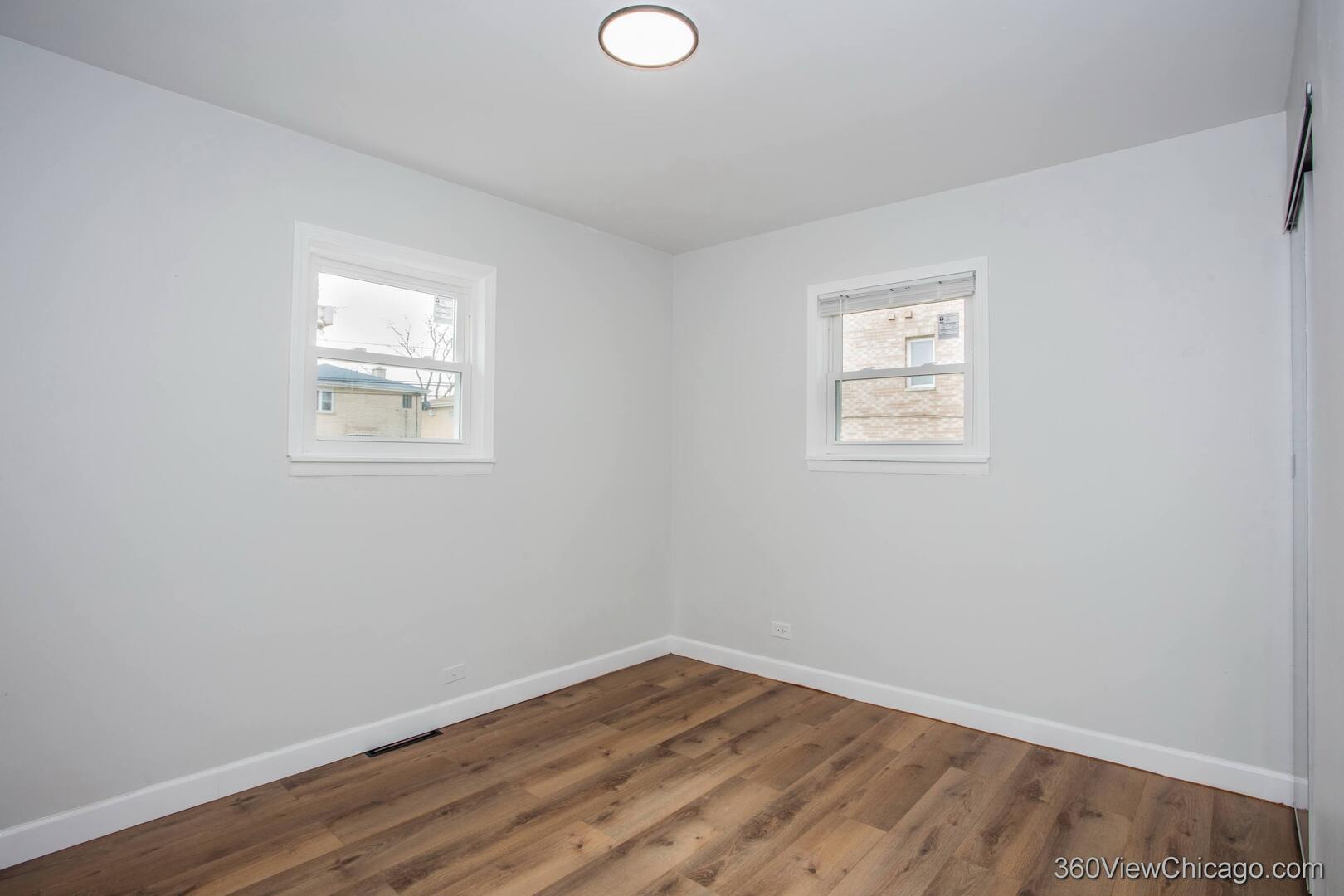 8651 44th Street Lyons, IL 60534 - Photo 18 of 31 an empty room with wooden floor and windows