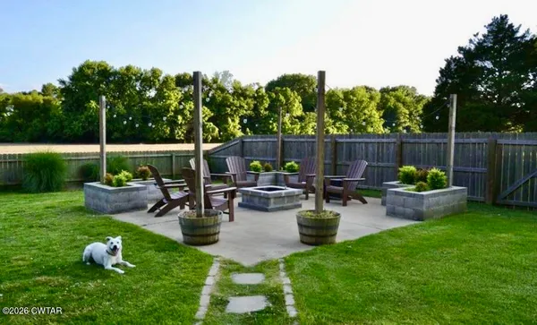 a view of a backyard with lawn chairs potted plants and a palm tree