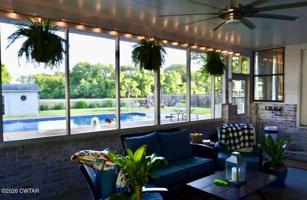 a dining room with furniture a potted plant and a floor to ceiling window