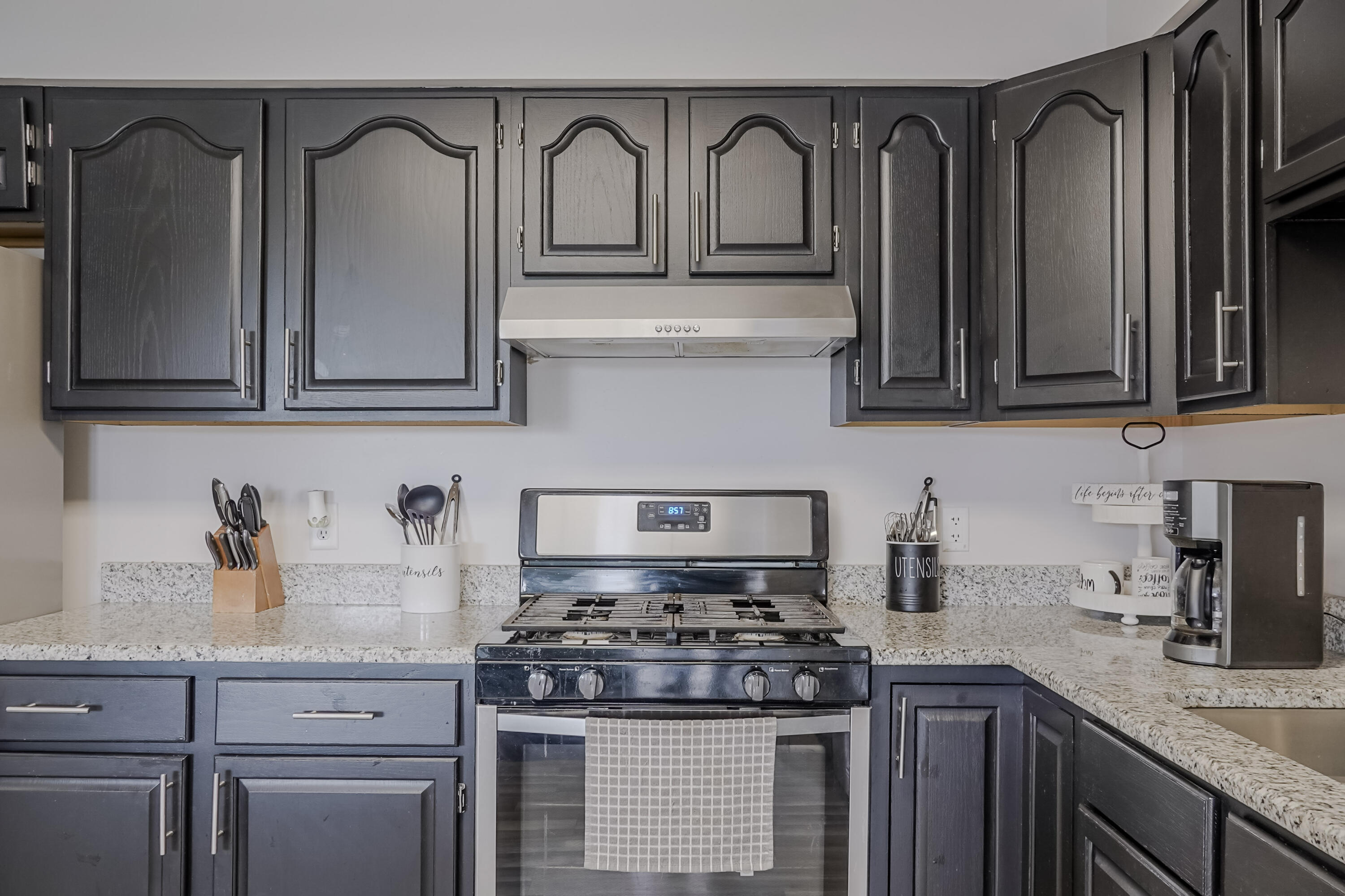 5065 Spinnaker Lane, Unit E Crown Point, IN 46307 - Photo 13 of 43 a kitchen with granite countertop a stove top oven a sink dishwasher and cabinets with wooden floor