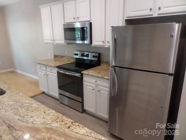 a white refrigerator freezer and a stove sitting inside of a kitchen