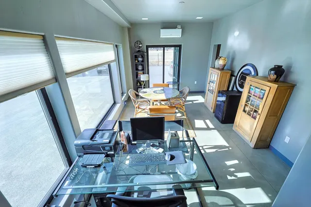 a kitchen with stainless steel appliances kitchen island granite countertop a table chairs and a refrigerator