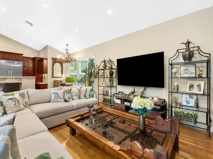 a living room with furniture a flat screen tv and a large window