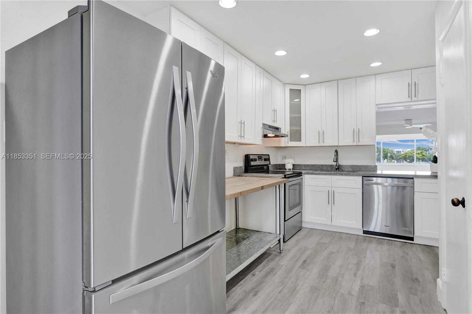 873 Northeast 195th Street, Unit 309 North Miami Beach, FL 33179 - Photo 12 of 35 a kitchen with white cabinets and white appliances