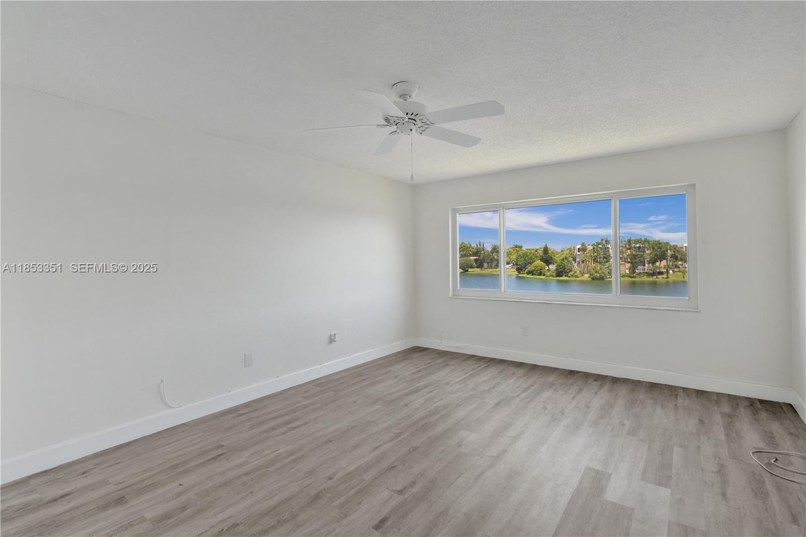 873 Northeast 195th Street, Unit 309 North Miami Beach, FL 33179 - Photo 14 of 35 an empty room with wooden floor and window