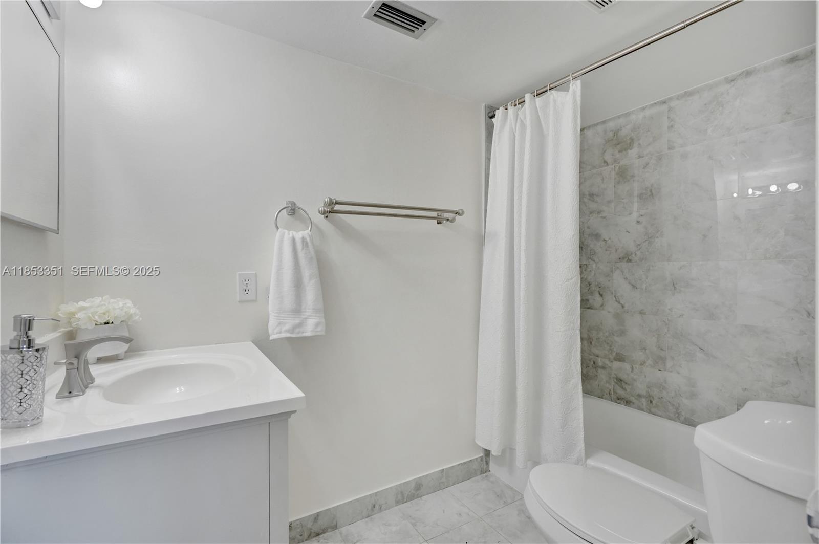 873 Northeast 195th Street, Unit 309 North Miami Beach, FL 33179 - Photo 22 of 35 a bathroom with a sink toilet and shower