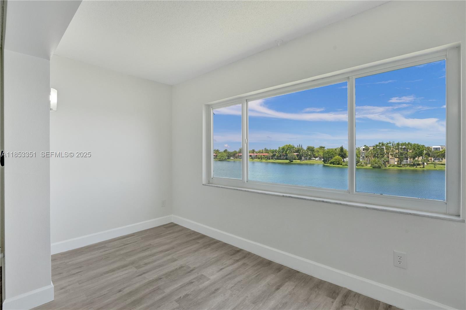 873 Northeast 195th Street, Unit 309 North Miami Beach, FL 33179 - Photo 8 of 35 wooden floor in an empty room with a window