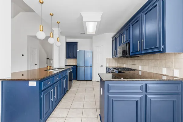 a kitchen with stainless steel appliances granite countertop a stove a sink and a microwave