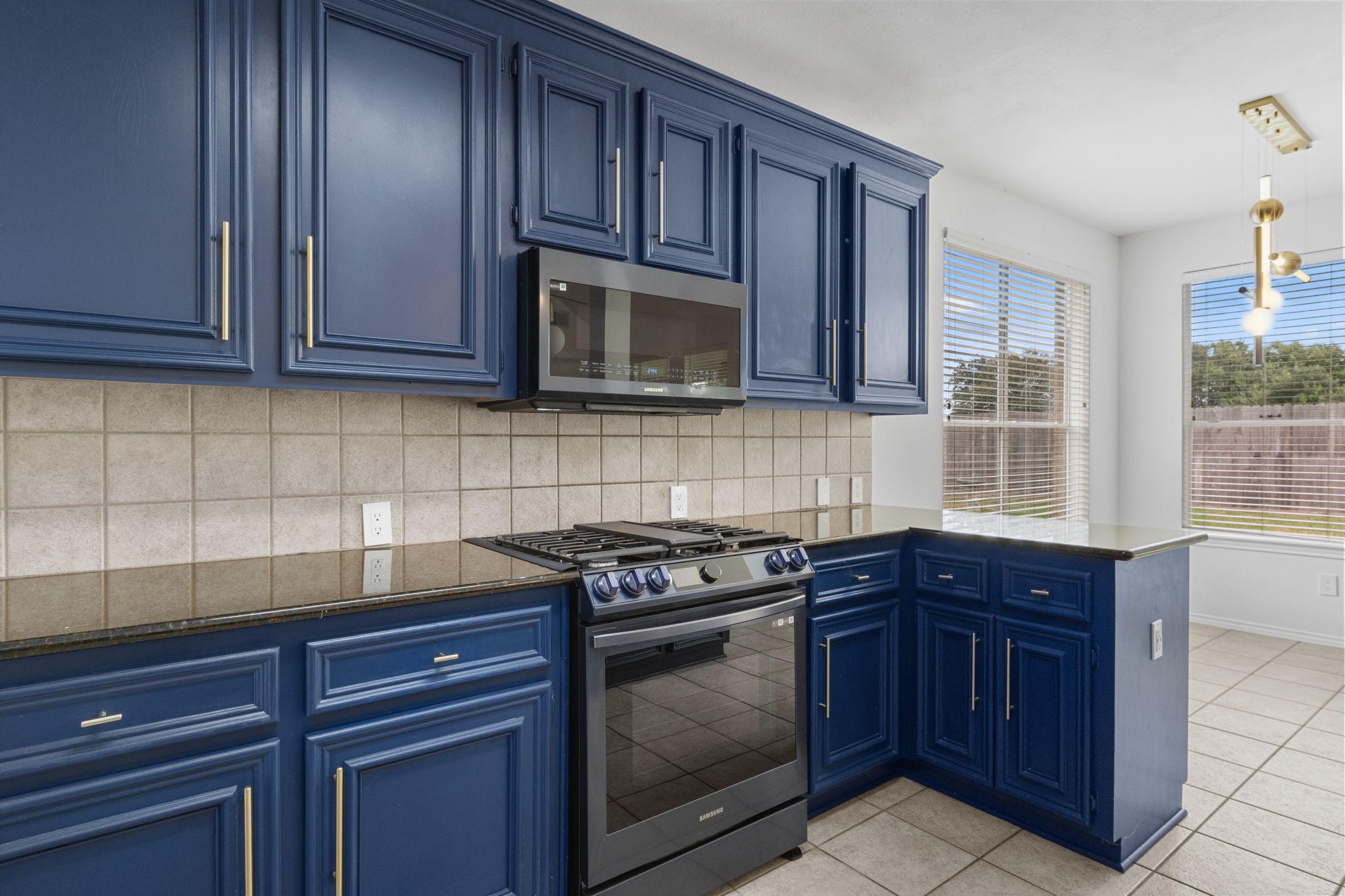 16202 Lasting Light Lane Houston, TX 77095 - Photo 17 of 36 a kitchen with granite countertop wood cabinets stainless steel appliances and a window