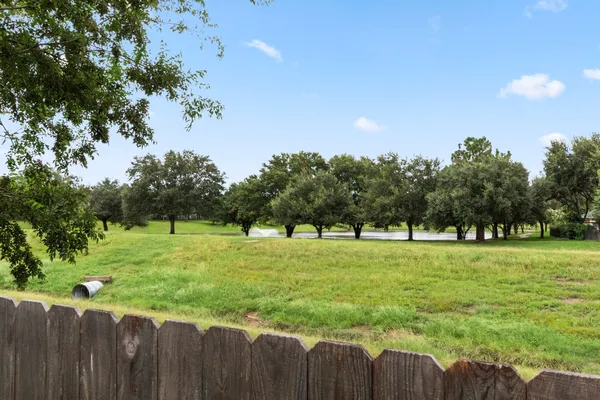 a view of a house with backyard and trees