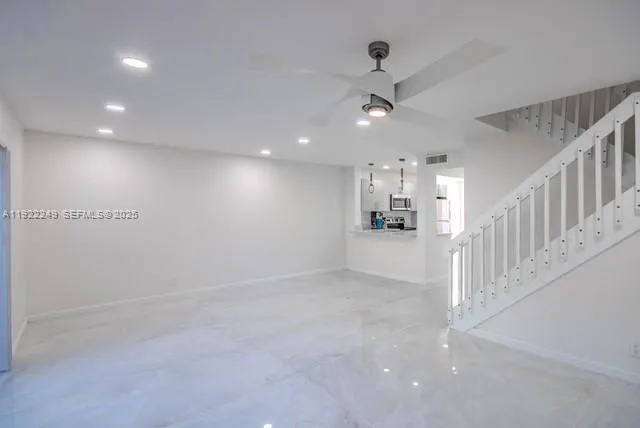 an empty room with windows and fan